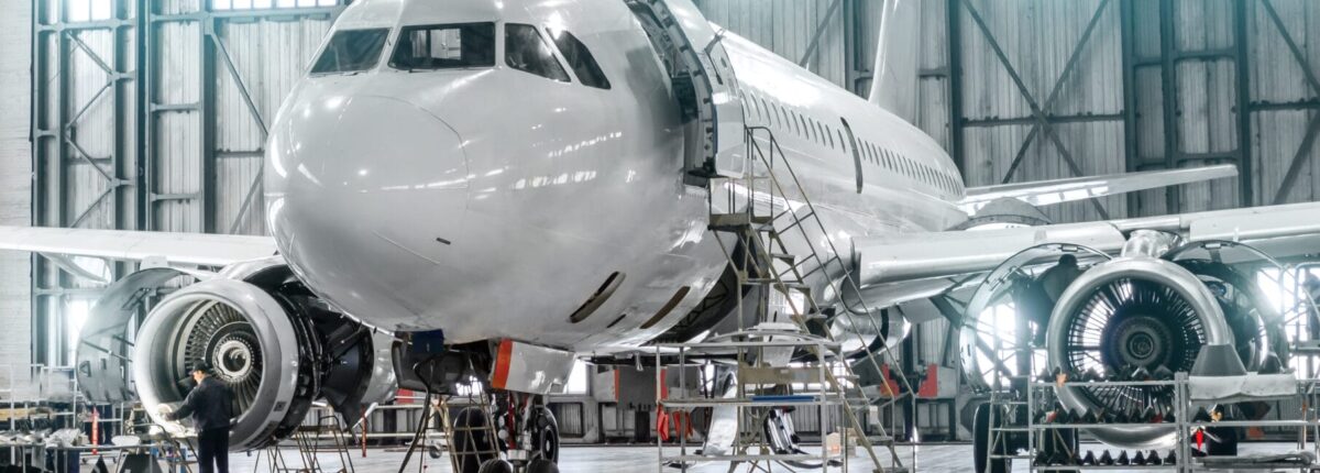 Maintenance of passenger aircraft in airport hangar.