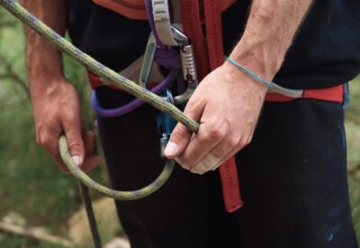 A person equipped with a rope and climbing gear.